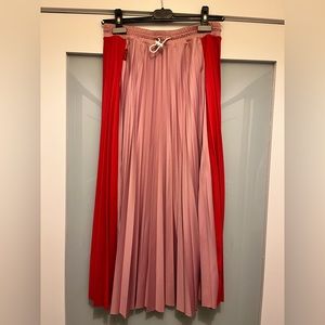 Mid length 2 tone pleated skirt with toggle waist band.